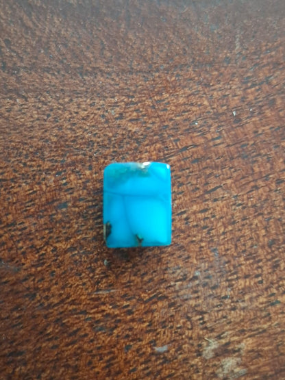 Turquoise stone on a brown wooden surface